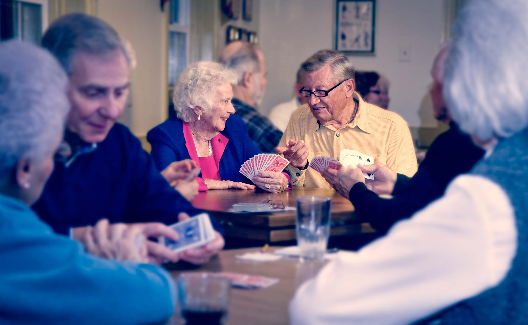 Senior Citizen Couple staying mentally active playing cards with friends