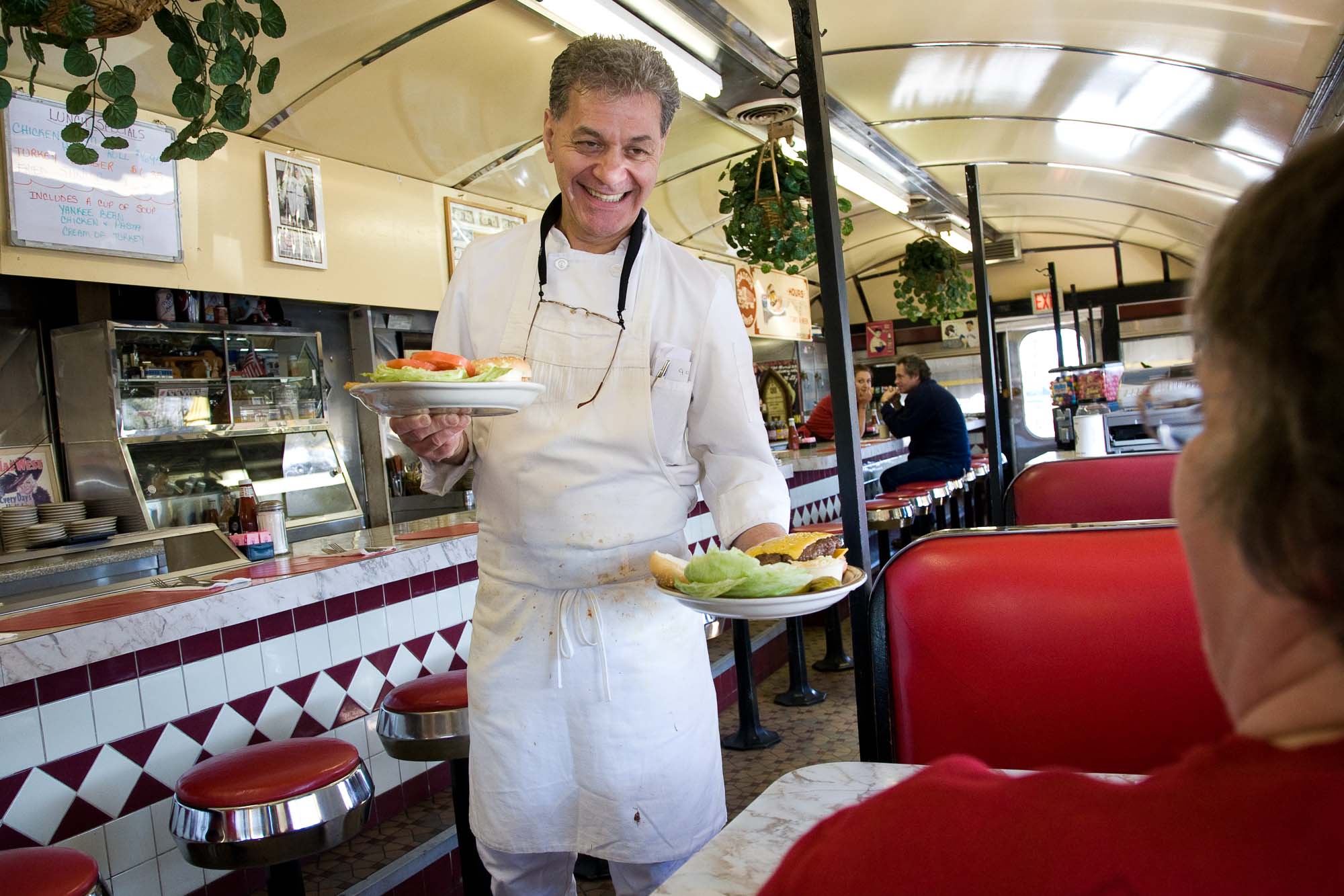 Senior citizen working in his diner, staying engaged in his community