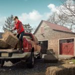 Active Senior working and lifting hay